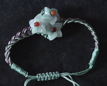 Bracelet en jade. Trois fleurs en jade mont�es sur fils tress�s. Jade-France.