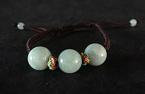 Bracelet en pierre de jade. Trois boules de jade mont�es sur fils tress�s. Jade-France