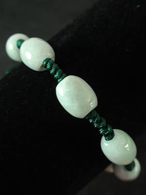 Bracelet en jade. 7 perles ovales mont�es sur fils tress�s. Jade-France