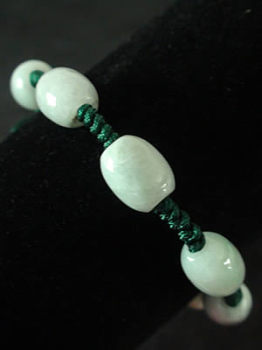 Bracelet en jade. 7 perles ovales mont�es sur fils tress�s. Jade-France