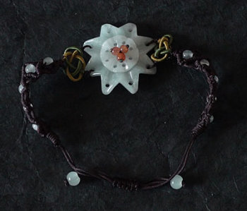 Bracet en pierre de jade. Fleur et perles de jade mont�es sur coton tress�. Jade-France
