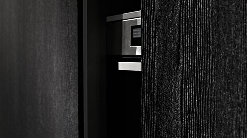 Eggersmann-K&uuml;che: Inselblock Granit Cashmere White | Detail Hochschr&auml;nke Blockfurnier schwarz mit hellen Adern, Hochglanzlackiert