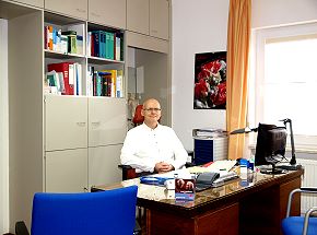 Teilansicht des Sprechzimmers, Dr. B&ouml;hme am Schreibtisch