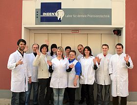 Dentaltechnik Indent GmbH - Das Team steht winkend vor dem Gebaeude