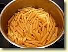 Penne rigate bis kurz vor 'al dente' kochen und Wasser abgiessen