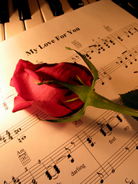 Liebesspr&uuml;che aus Liedertexten - die Rose auf dem Notenblatt mit dem Love Song, gefunden auf www.liebesspr&uuml;che.eu
